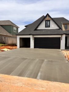 residential concrete project with white house and black roof