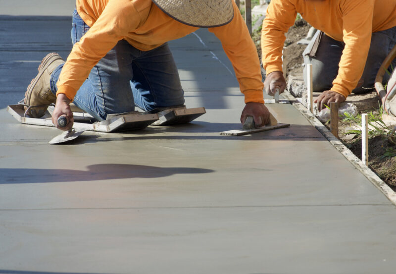 Construction workers putting finishing touch on the freshly poured concrete